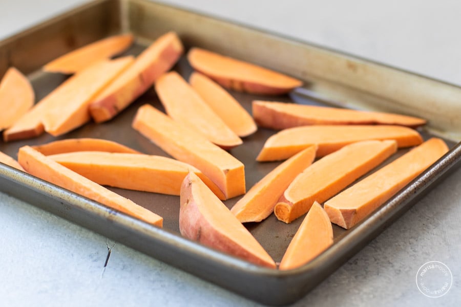 sliced sweet potato wedges on a sheet pan