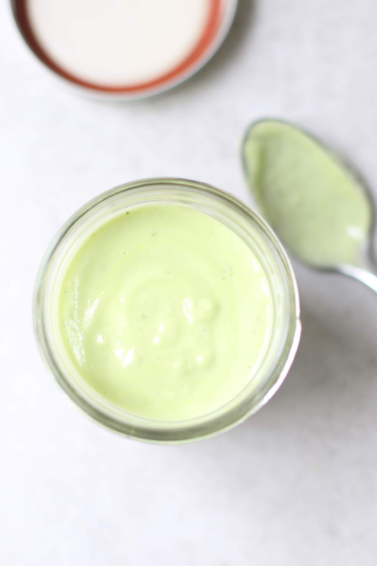 Overhead Avocado Lime Dressing in a jar with a spoon