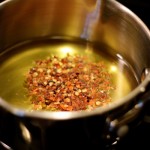 Oil with chili flakes in a pot on the stove