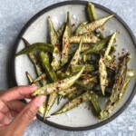 Roasted okra on a plate with Marisa holding one piece
