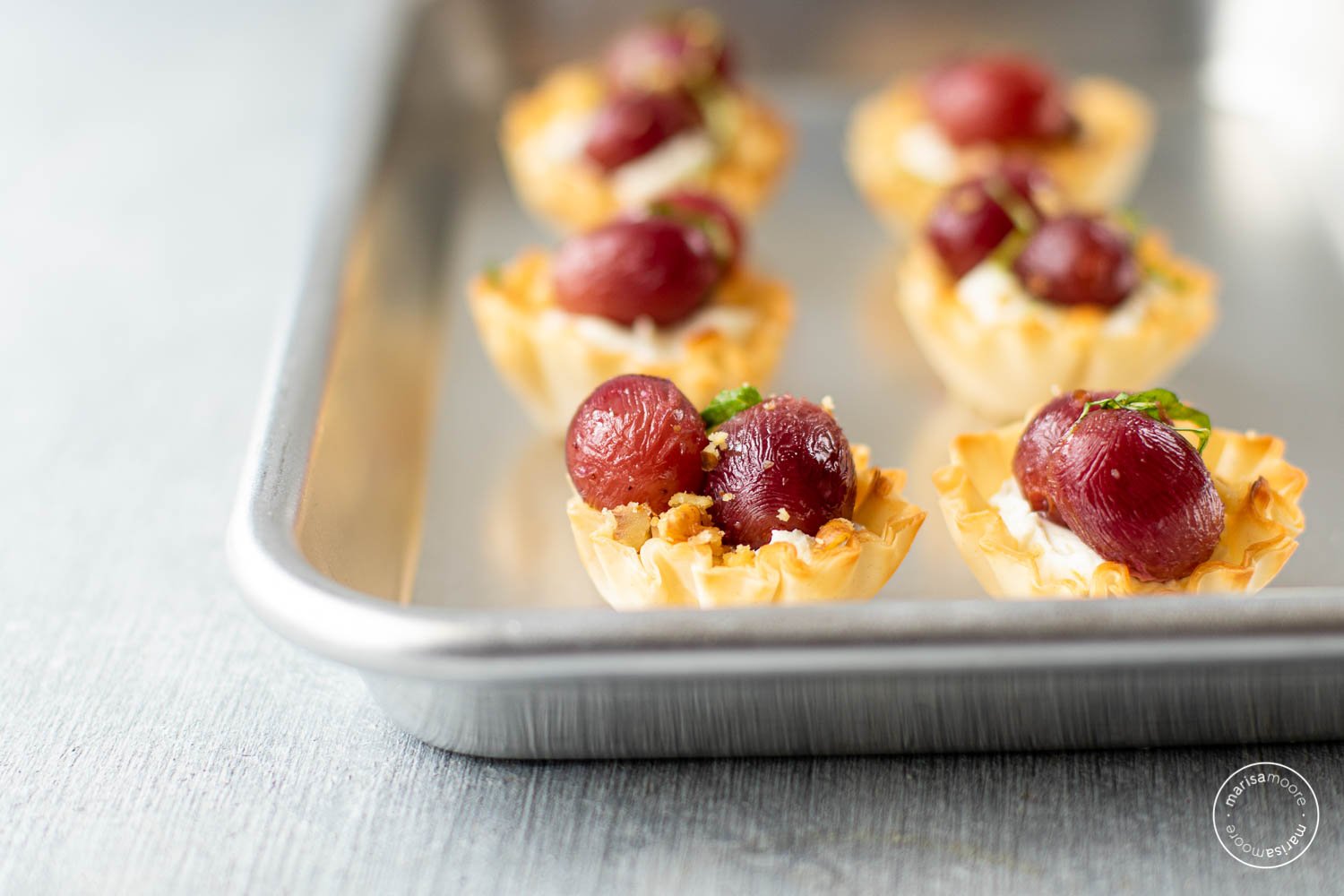 grape and ricotta walnut bites on a sheet tray