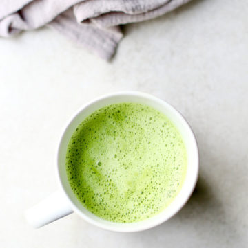 Matcha Latte in a white mug with a gray linen