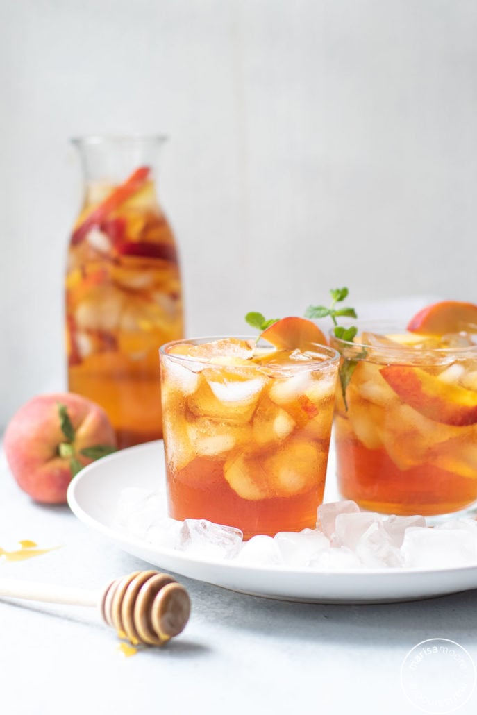 Iced Tea with peaches with a honey spoodle in front