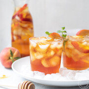 Iced Tea with peaches with a honey spoodle in front