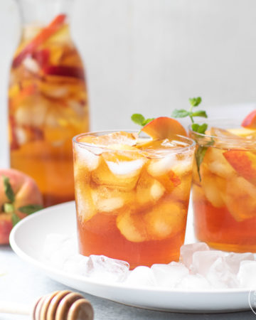 Iced Tea with peaches with a honey spoodle in front