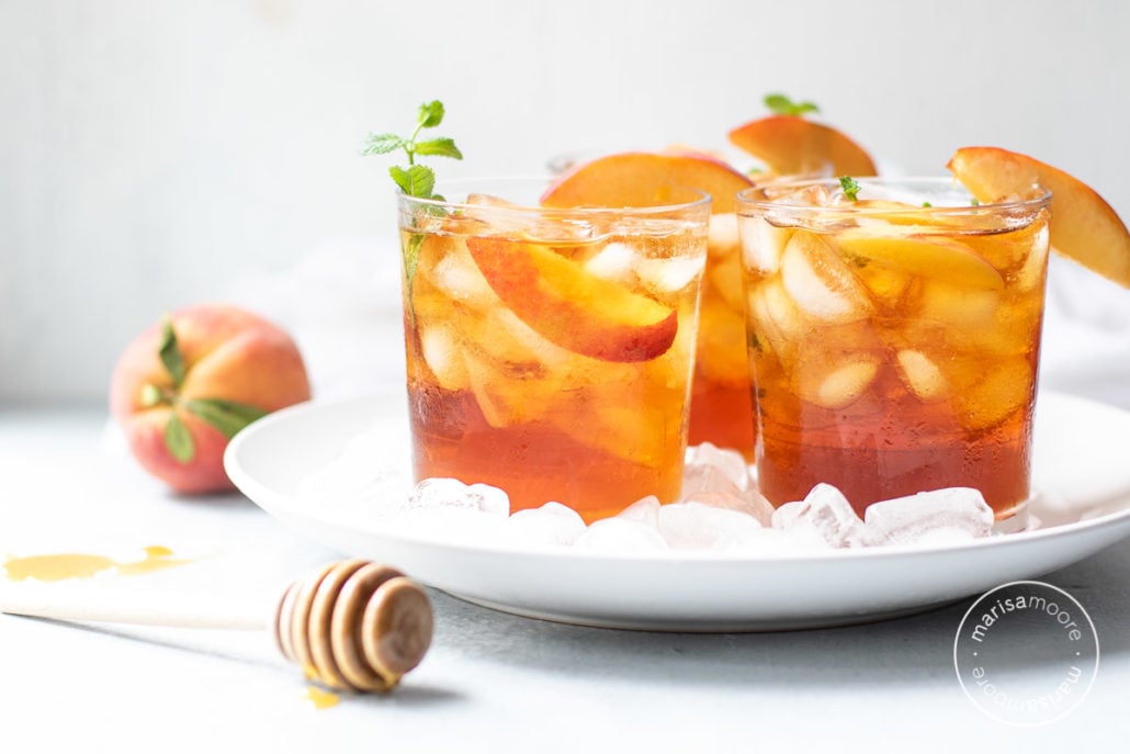 Iced Tea with peaches with a honey spoodle in front