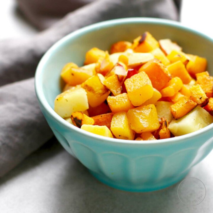 Roasted squash and apples in a blue bowl.