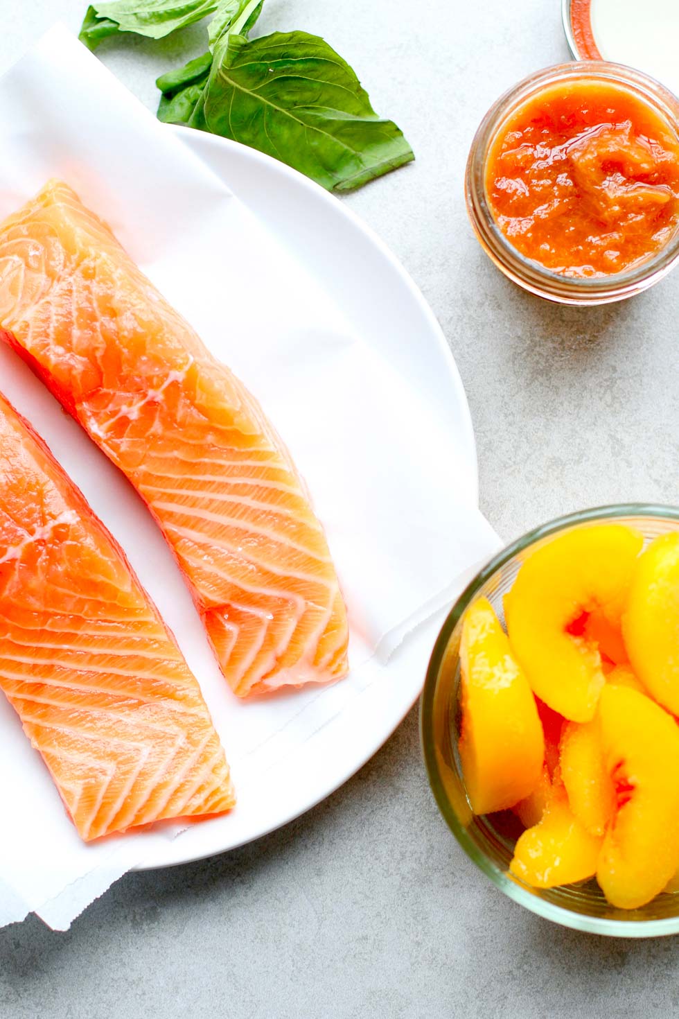 sliced salmon fillets, peaches, peach jam in a jar