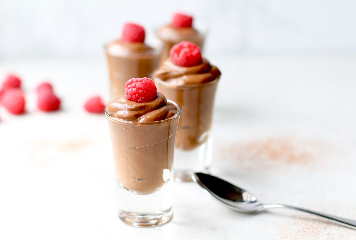 Vegan Chocolate Avocado Pudding with raspberries and a spoon