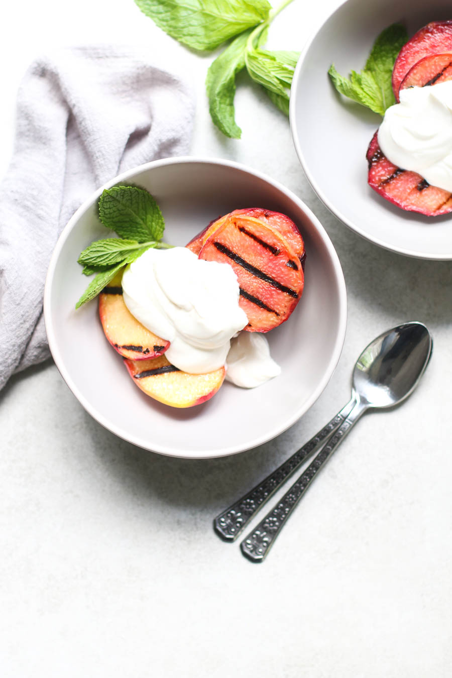 Grilled Peaches and Cream in Bowls with 2 spoons