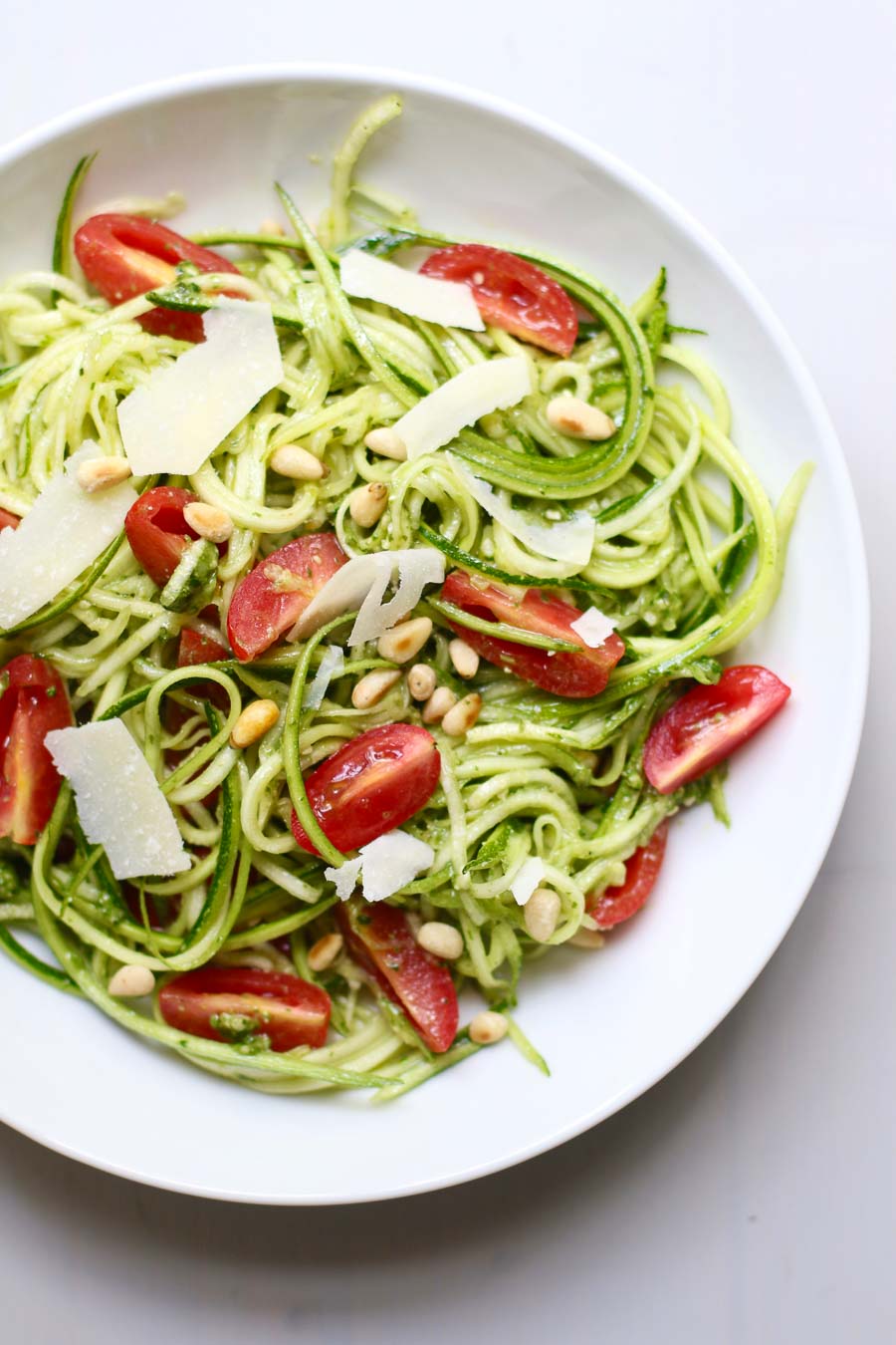 Pesto Zucchini Noodle Salad topped with pine nuts and shaved parmesan