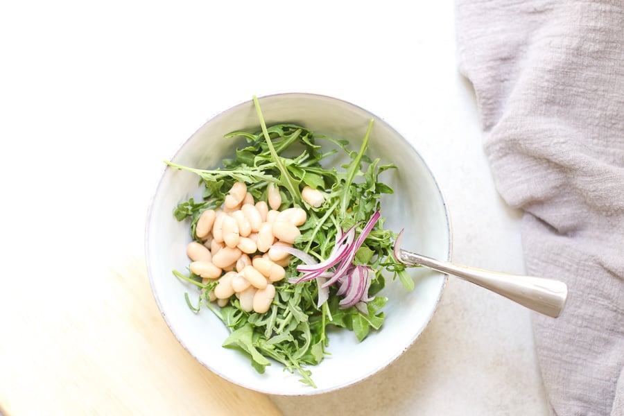 White Bean Arugula in Salad bowl with fork to mix