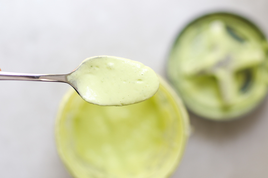 Avocado Salad dressing on a spoon over the blender cup