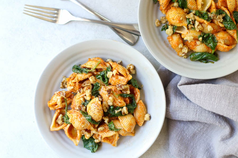 Pumpkin Pasta with Toasted Walnuts and Spinach in bowls with two forks