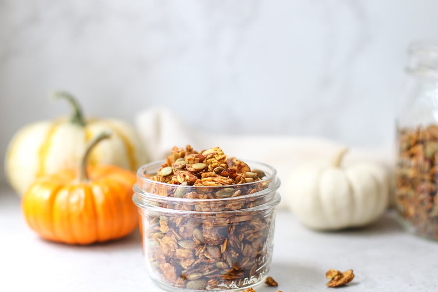 Pumpkin spice granola in a jar with mini pumpkins