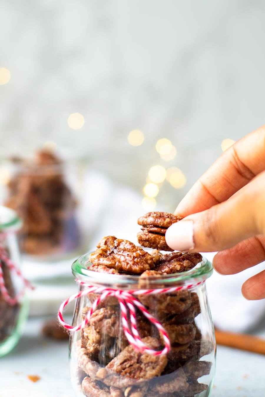 hand taking one pecan from a jar 1