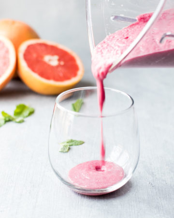 Pouring smoothie into a short glass