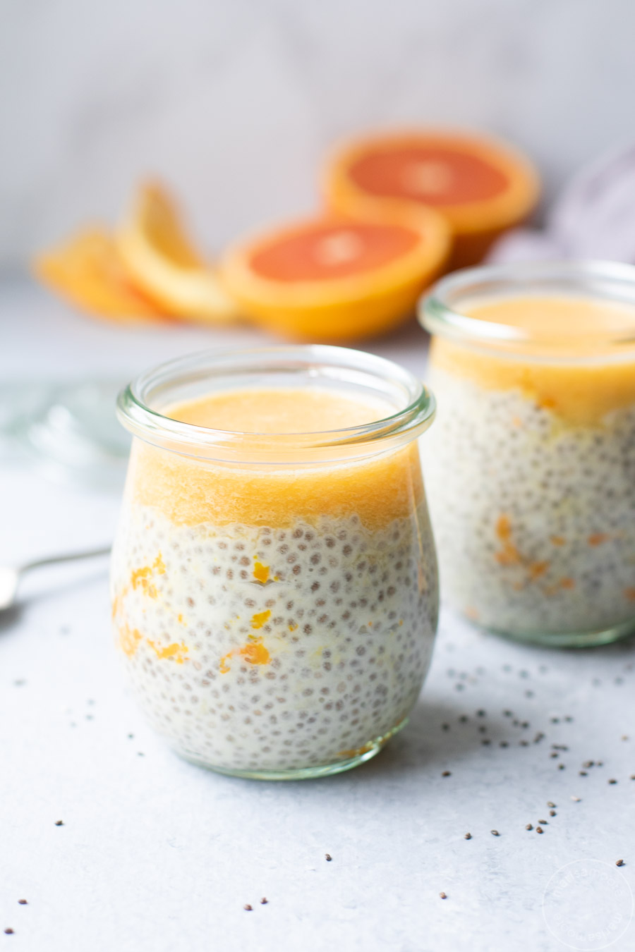 creamsicle chia pudding in jars with oranges in background