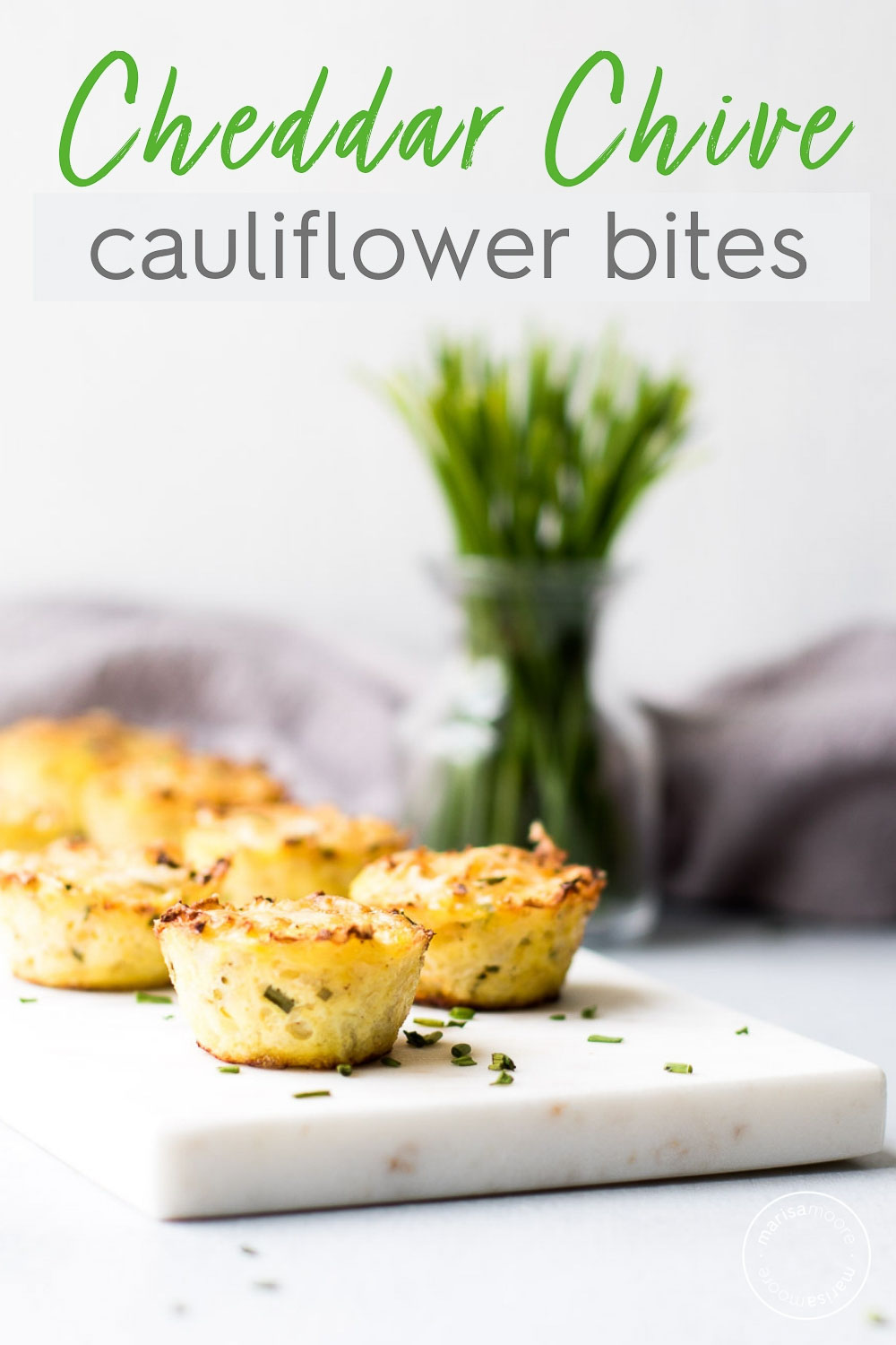 Cheese and Chive Cauliflower Bites on Marble with chives in the back