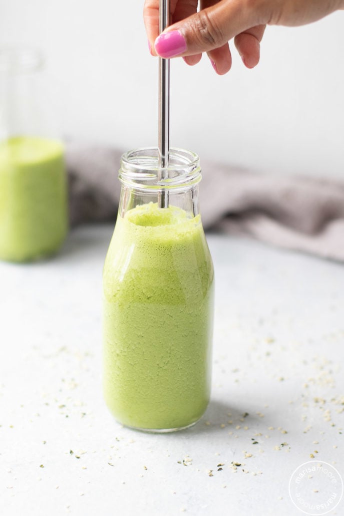 Green smoothie with hemp seeds and a straw going in