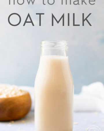 oat milk in a bottle with dry oats scattered around