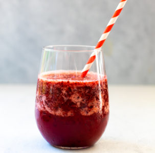 Cherry Slush in a glass with a red and white straw