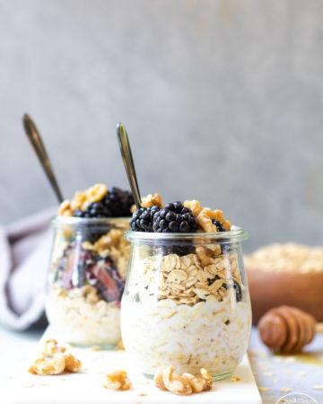Blackberry Walnut Overnight Oats in jars with oats background