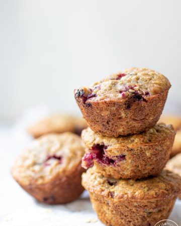 Stacked Blackberry Buttermilk Muffins on a white backdrop