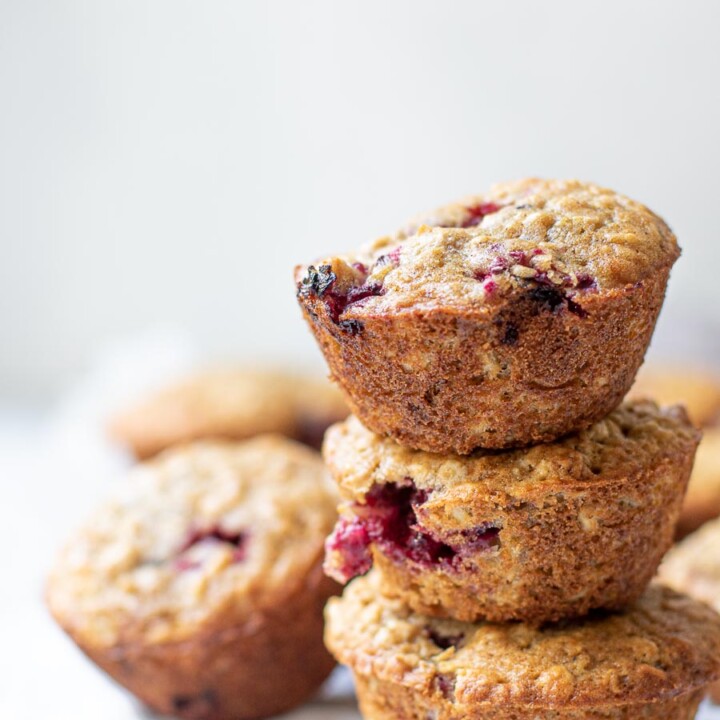 Stacked Blackberry Buttermilk Muffins on a white backdrop