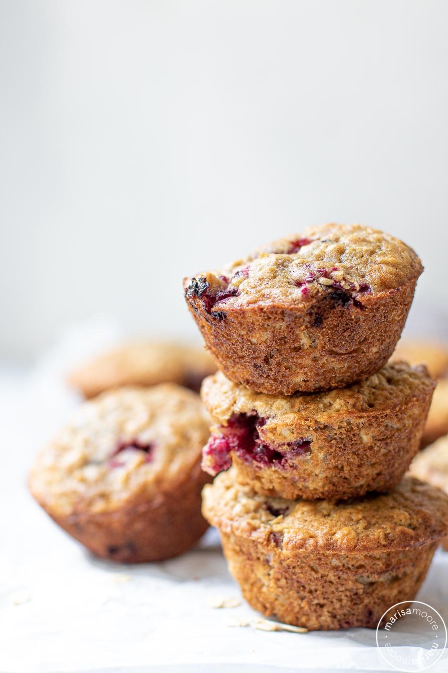 Stacked Blackberry Buttermilk Muffins on a white backdrop