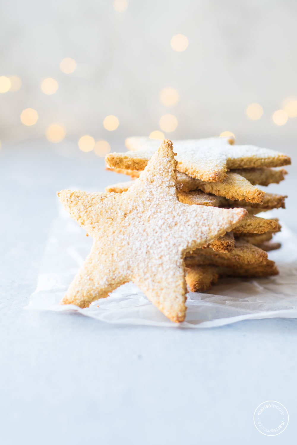 Sugar cookies stacked with lights in the background