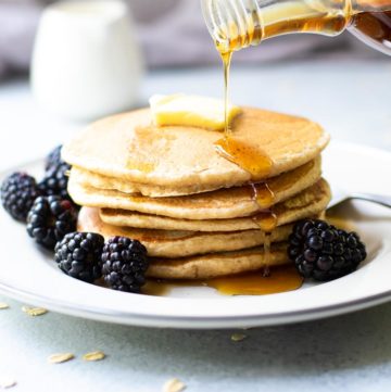 Oat Flour Pancakes with Syrup pouring and blackberries