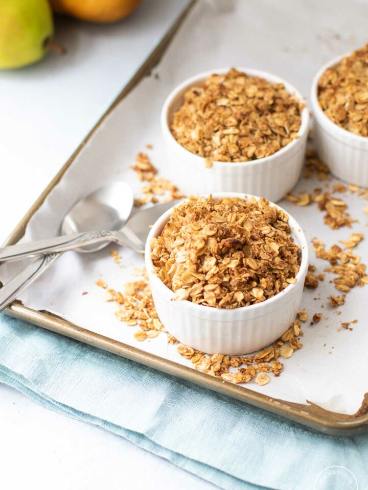Cooked pear crisp on sheet pan with spoons and blue napkin