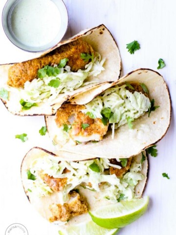 Fish tacos with a jar of cilantro spilling out