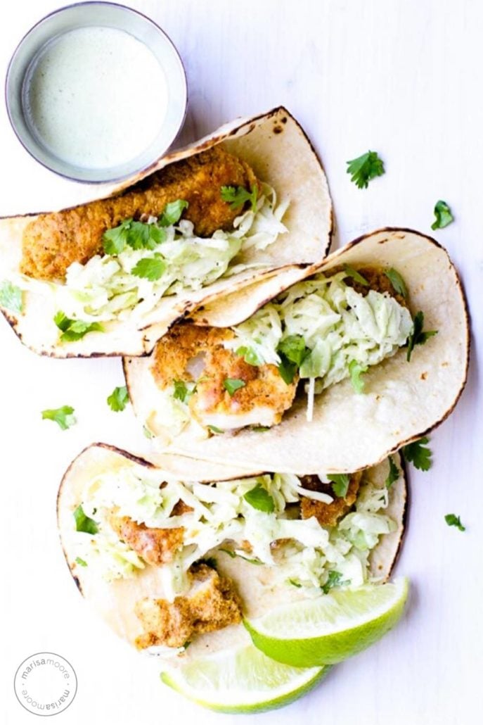 Fish tacos with a jar of cilantro spilling out