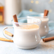 clear glass mug of vegan eggnog with spices on top