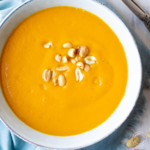 sweet potato soup in a grey bowl with blue napkin