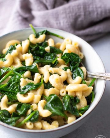 bowl of spinach mac and cheese with a spoon