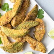 cornmeal breaded avocado fries on white plate with cilantro