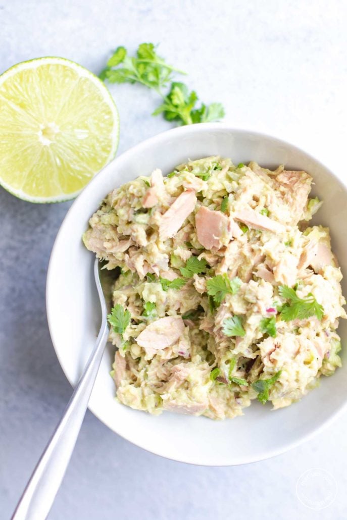 avocado lime tuna salad in white bowl with a fork