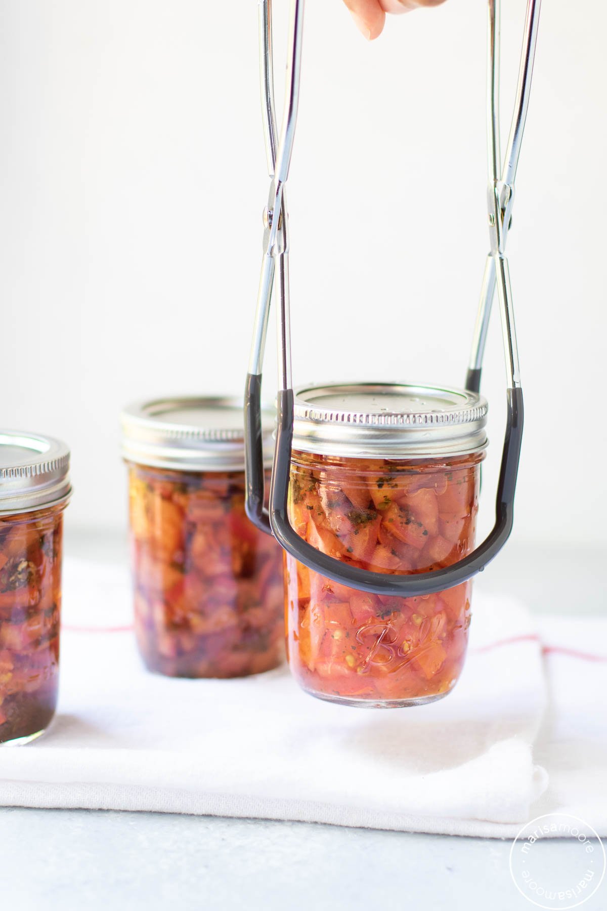 setting down a jar of tomatoes onto a towel