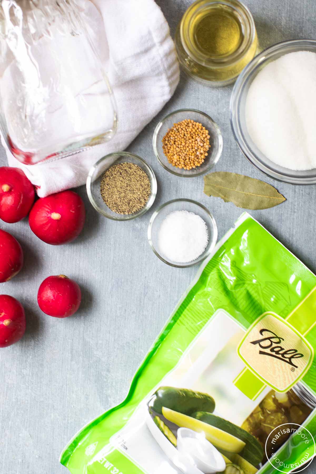 radishes, pickling salt, sugar, vinegar, and spices on a grey board