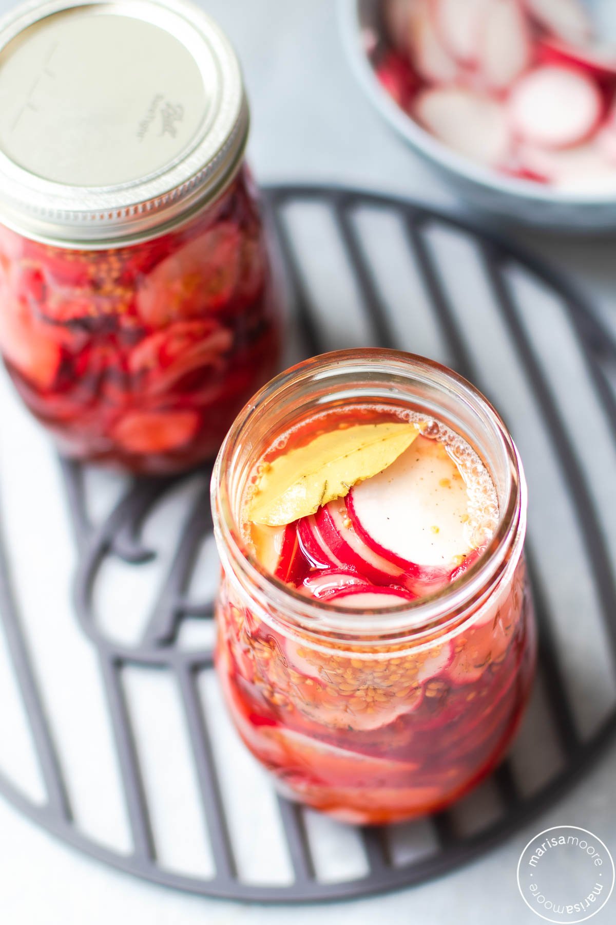 Overhead shot of radishes in brine in jars