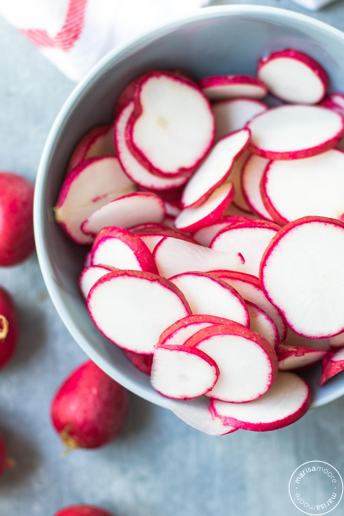 Sliced radishes in a blue bowl