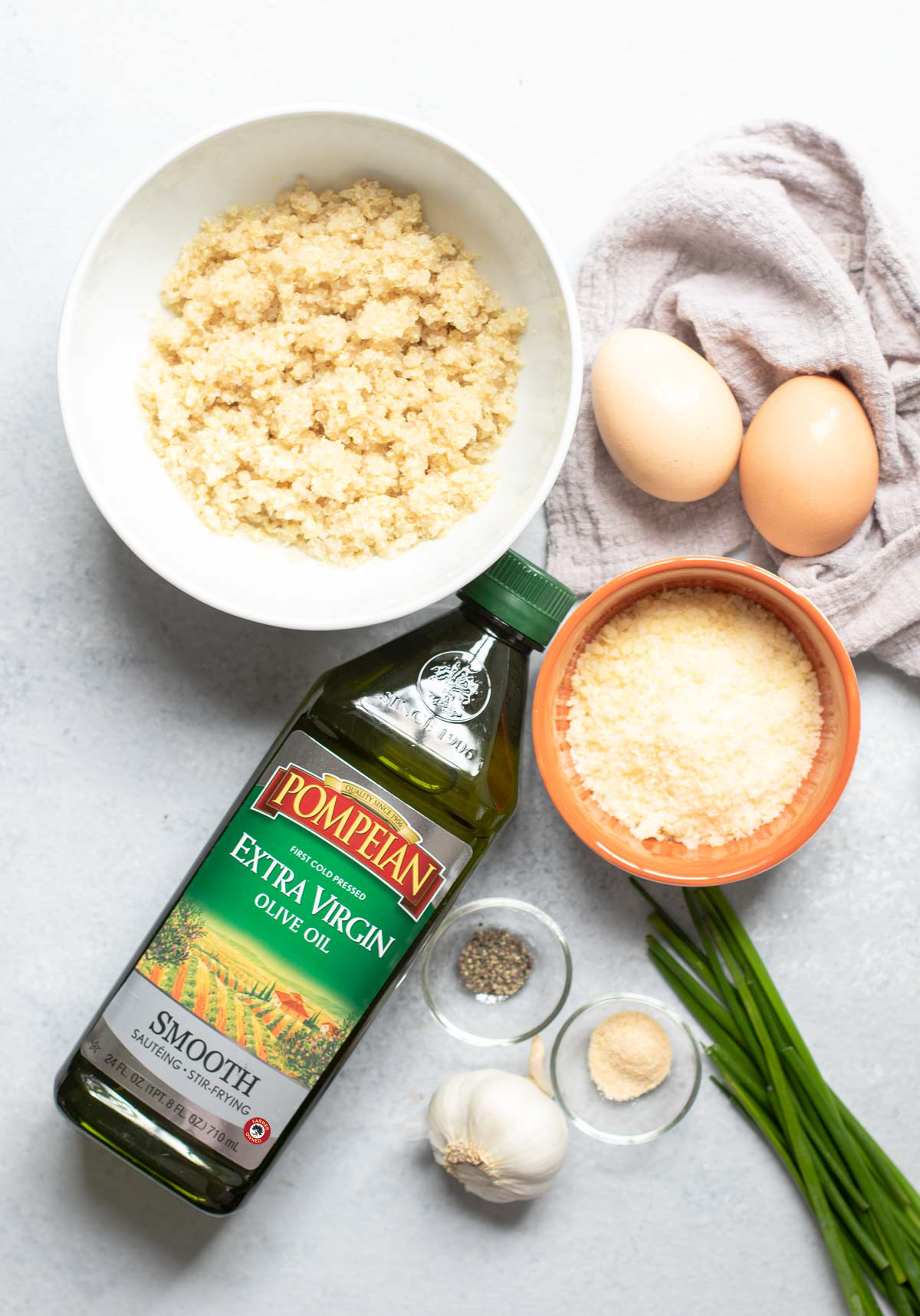 Bottle of oil, spices, quinoa and parmesan in bowls , eggs, fresh chives