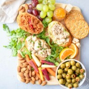 Snack board with tuna toasts, fruit, vegetables and nuts