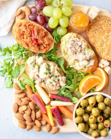 Snack board with tuna toasts, fruit, vegetables and nuts