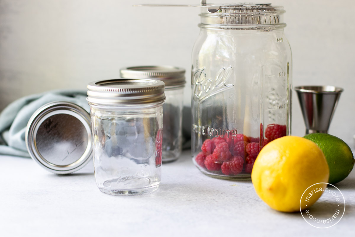 glass jars with lemon, lime and raspberries