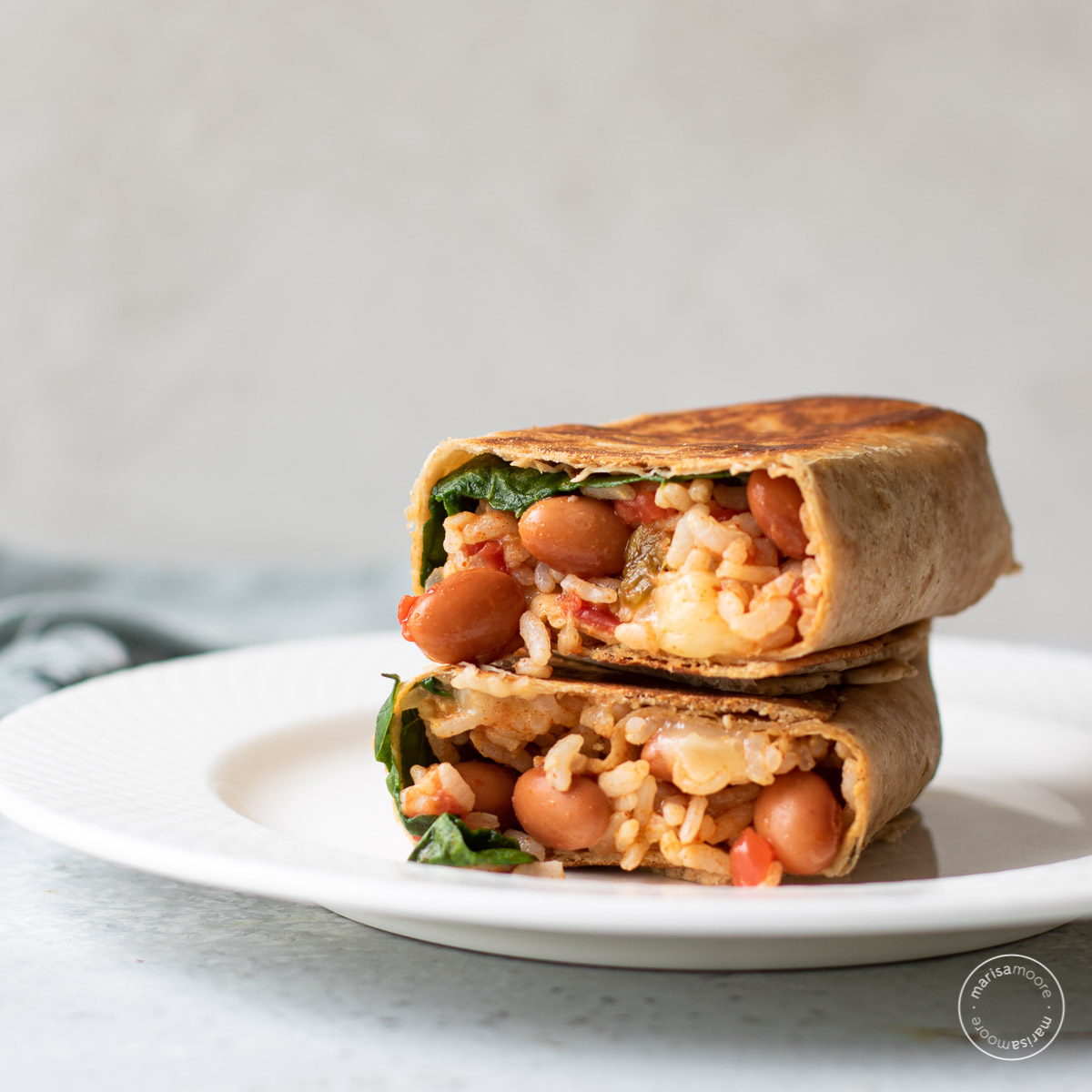 Pinto Bean and Cheese Burritos Stacked on a plate