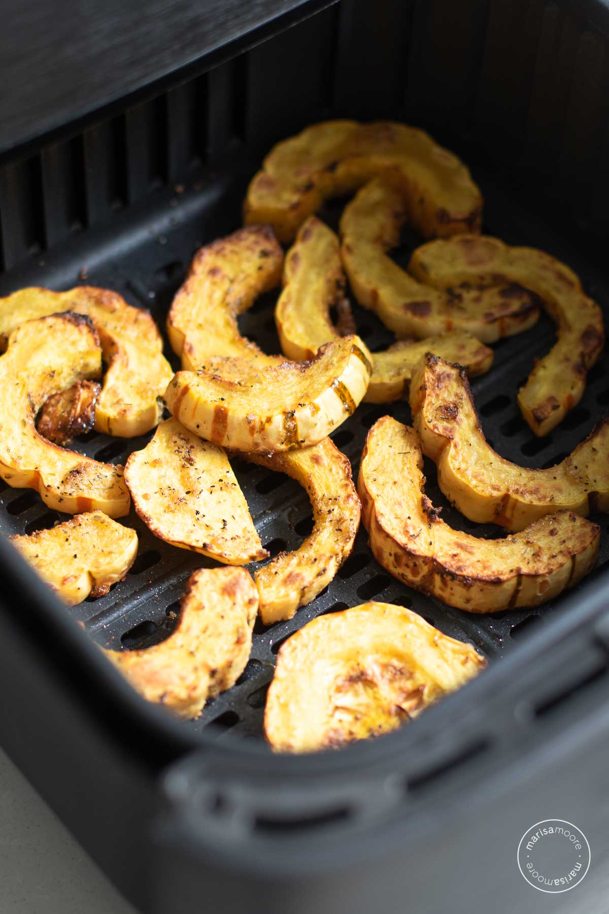 Cooked delicata squash in the air fryer basket